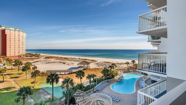 Ein Resort mit Pool, Blick auf den Strand und einem Hochhaus.