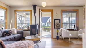 A cozy living room with a sofa, a furry rug, a round coffee table, and a fireplace.