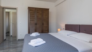 Ein Schlafzimmer mit Bett, Kleiderschrank und Nachttisch mit Lampe.