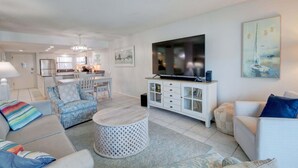 A modern living room with a TV, sofa, and dining area. - 346 El Matador 2 Bedroom Home by RedAwning (Fort Walton Beach)