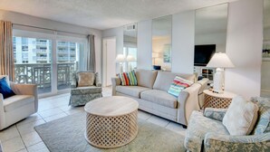 A modern living room with a sofa, armchairs, a round coffee table, and a large mirror. - 346 El Matador 2 Bedroom Home by RedAwning (Fort Walton Beach)