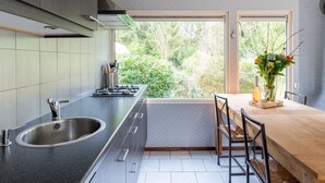 Una cucina moderna con un'isola grande, piano cottura integrato e una finestra vista giardino.