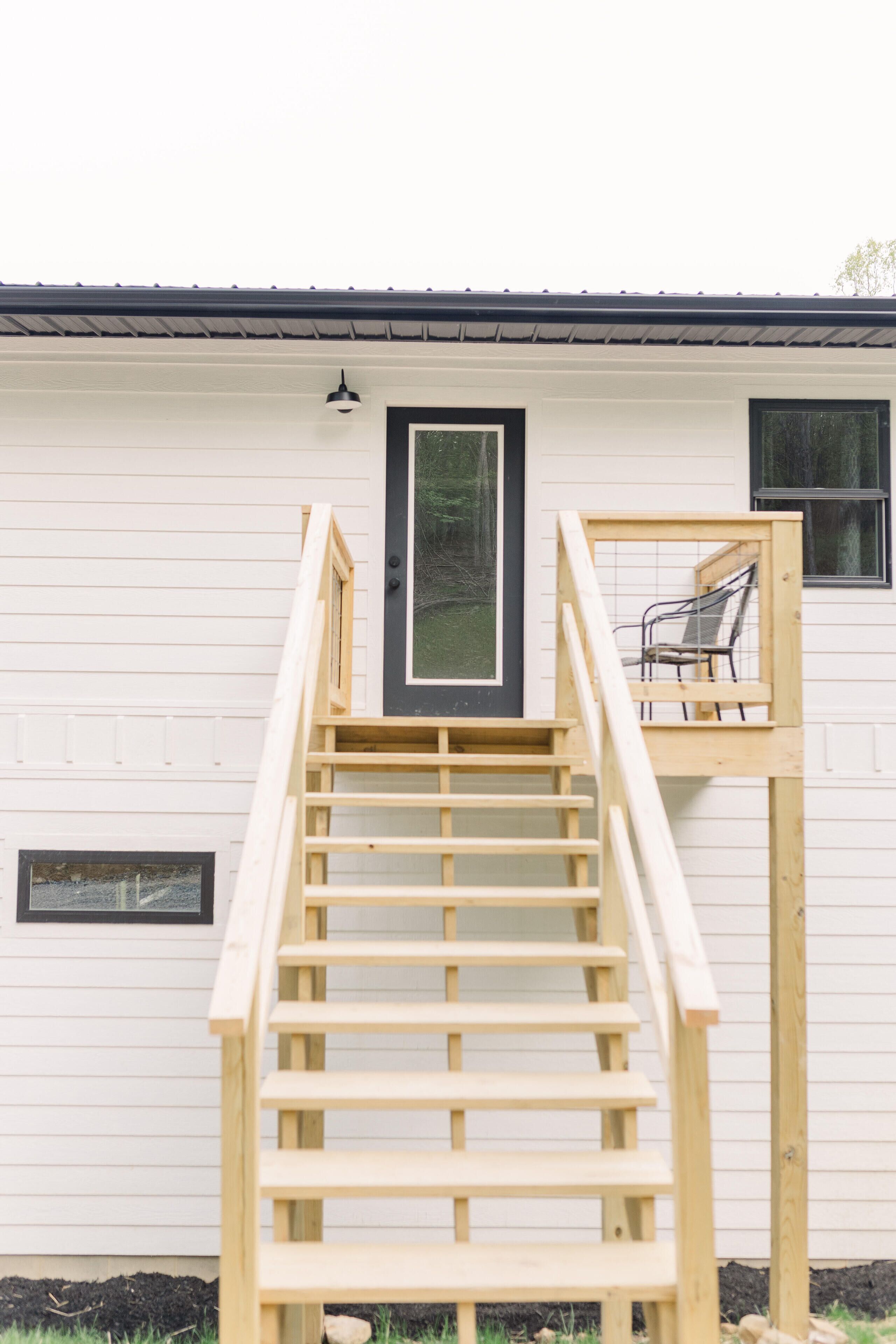 A wooden staircase leading to a deck with a bench.