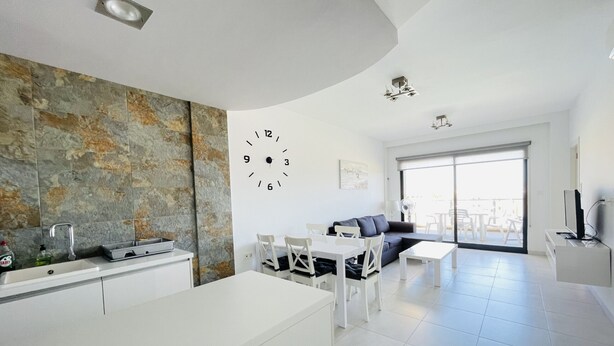 A modern living space with a kitchen, dining area, and a balcony with a view. - 3090 RESIDENCIAL SABRINA (Orihuela Costa)