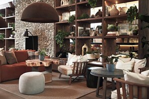 A cozy interior with a stone wall, wooden shelves, and various plants. - 1 Hotel Mayfair (London)