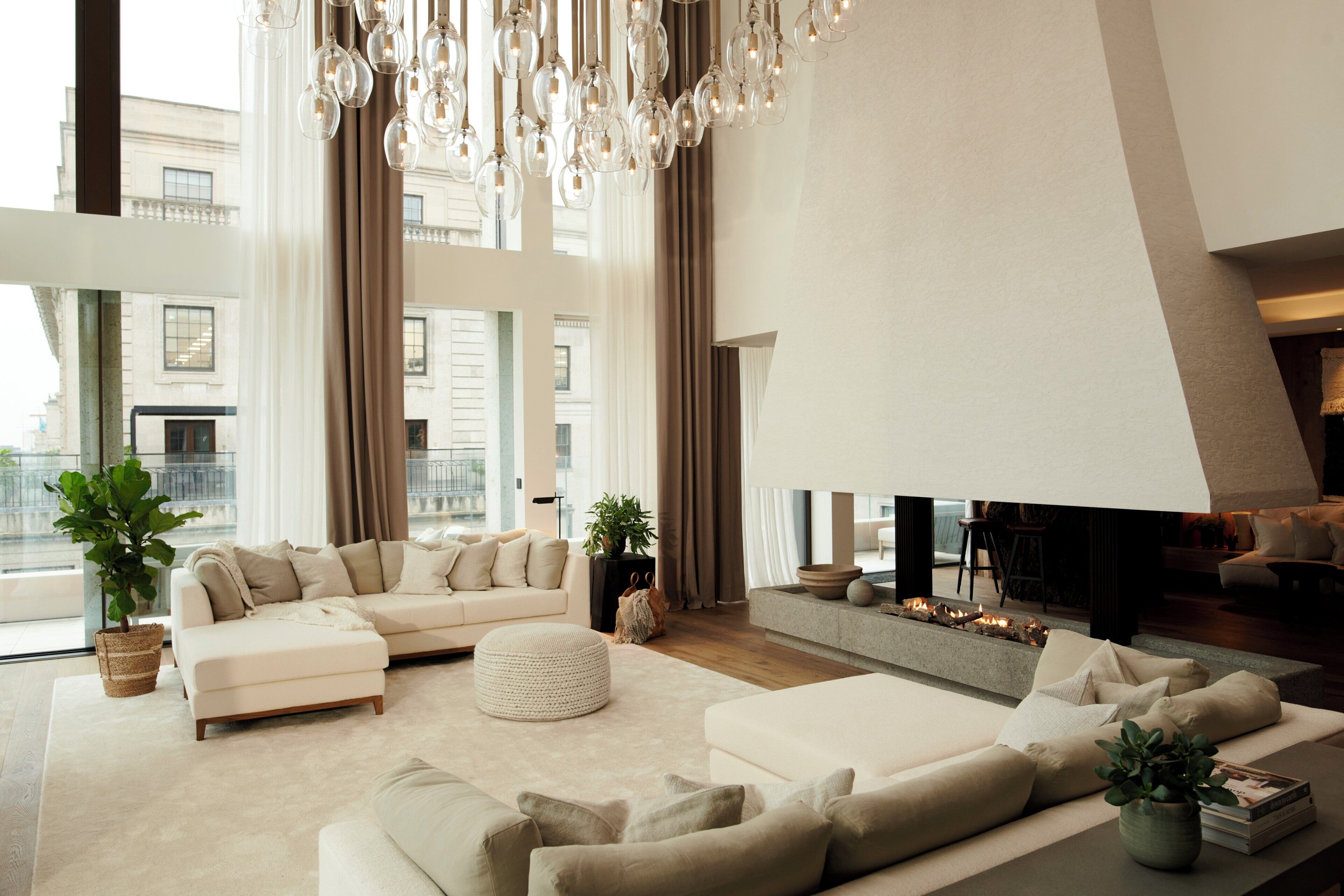 A spacious living area with a large sectional sofa, a fireplace, and a modern chandelier.