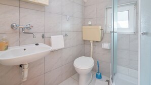 Een badkamer met een wastafel, toilet en douche.