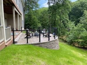 A covered patio with outdoor furniture and a stone retaining wall.
