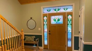 A wooden staircase leading to a room with a door featuring stained glass panels.