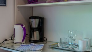 A kitchenette with a coffee maker, a kettle, and a tray with glasses and cups. - Apartments and Room Frane - Double Room (Dubrovnik)