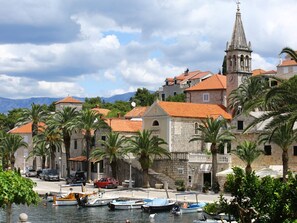 A coastal town with stone buildings, a church, and boats docked by the water. - Apartments Boro - Two Bedroom Apartment With Terrace (Supetar)