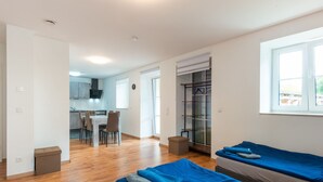 A modern, well-lit room with two beds, a small kitchenette, and a dining area. - Spacious Dual Guesthouse (Haunsheim)