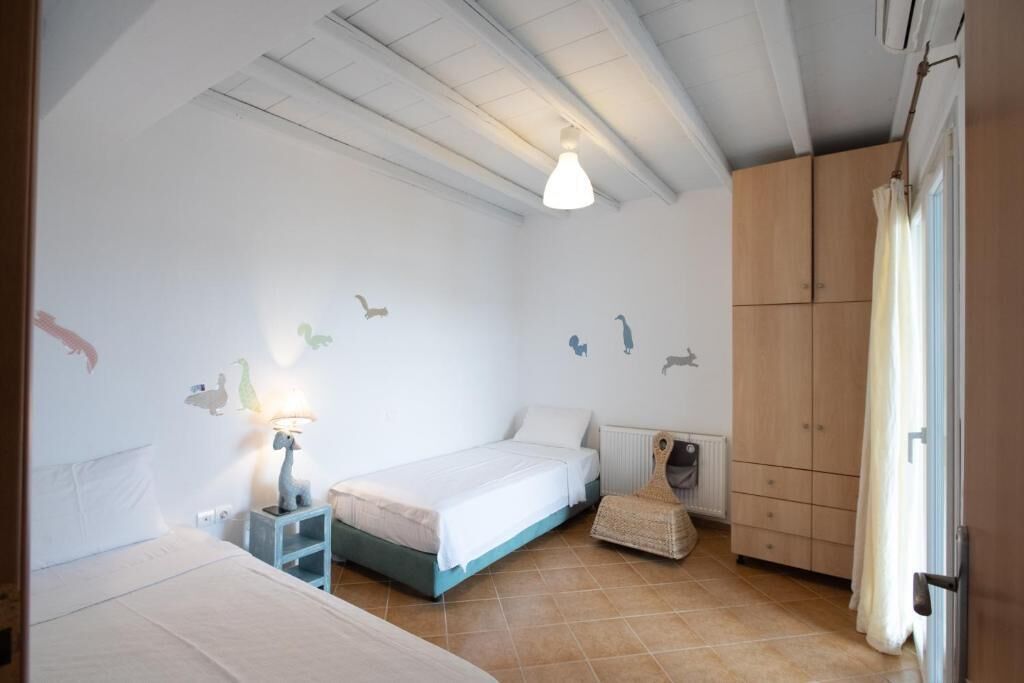 A bedroom with a bed, a nightstand, a lamp, a radiator, and a wardrobe.