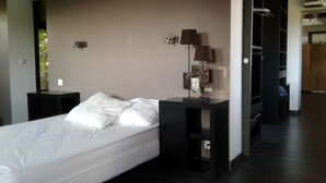 Une chambre à coucher moderne avec un lit, des tables de chevet, une lampe et une armoire.