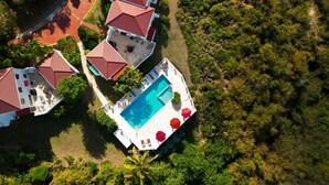 An aerial view of a resort with multiple buildings, a swimming pool, and lush greenery. - 2 bedroom, 2.5 bath with pool access & ocean view (Cruz Bay)