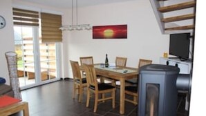 Un comedor con una mesa, sillas, televisor y chimenea.
