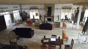 A spacious living room with a fireplace, multiple seating areas, and a dining table.