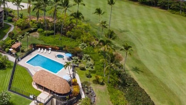 Un campo de golf con piscina y un edificio de techo de paja.