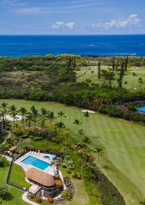 A golf course with a pool and a building with a thatched roof. - Keauhou Punahele#D-103 Ground Floor, Spacious Lanai, Personal BBQ, VERY Quiet (KONA)