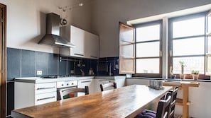 A modern kitchen with a central island, built-in appliances, and a large window with a view. - Welcomely- In Barberia Milis (Milis)