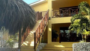 A two-story building with a staircase leading to a balcony. - Air-conditioned Mama Sha Apartment Near Jan Thiel (Jan Thiel)