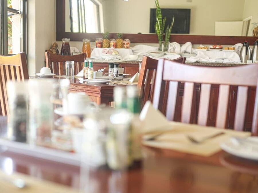 Un comedor con sillas de madera y una mesa dispuesta para el desayuno.