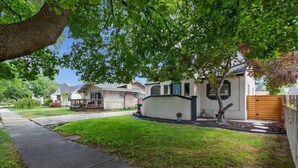 A residential house with a front yard, a sidewalk, and a wooden fence. - #StayinMyDistrict TwinFalls Tudor (Twin Falls)