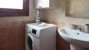 A compact laundry area with a washing machine and a sink.