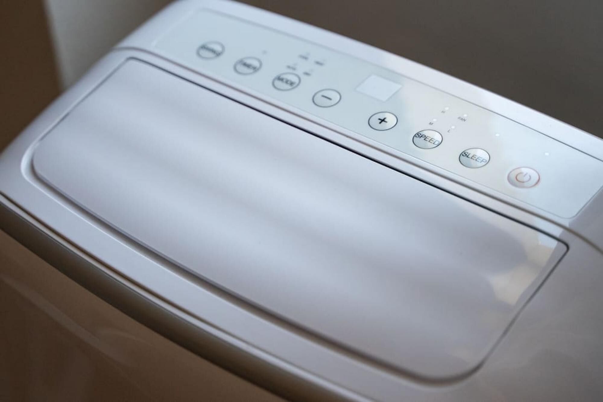A front view of a washing machine with control buttons including power, speed, and sleep mode.