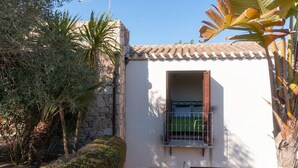 Un bâtiment avec un mur en pierre, une fenêtre avec des volets et une porte.