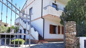 Ein zweistöckiges Haus mit Steinmauer und einem Metallgitter.