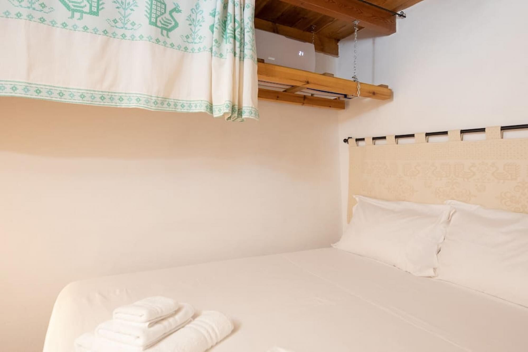 Un dormitorio con cama, almohadas y una toalla doblada.