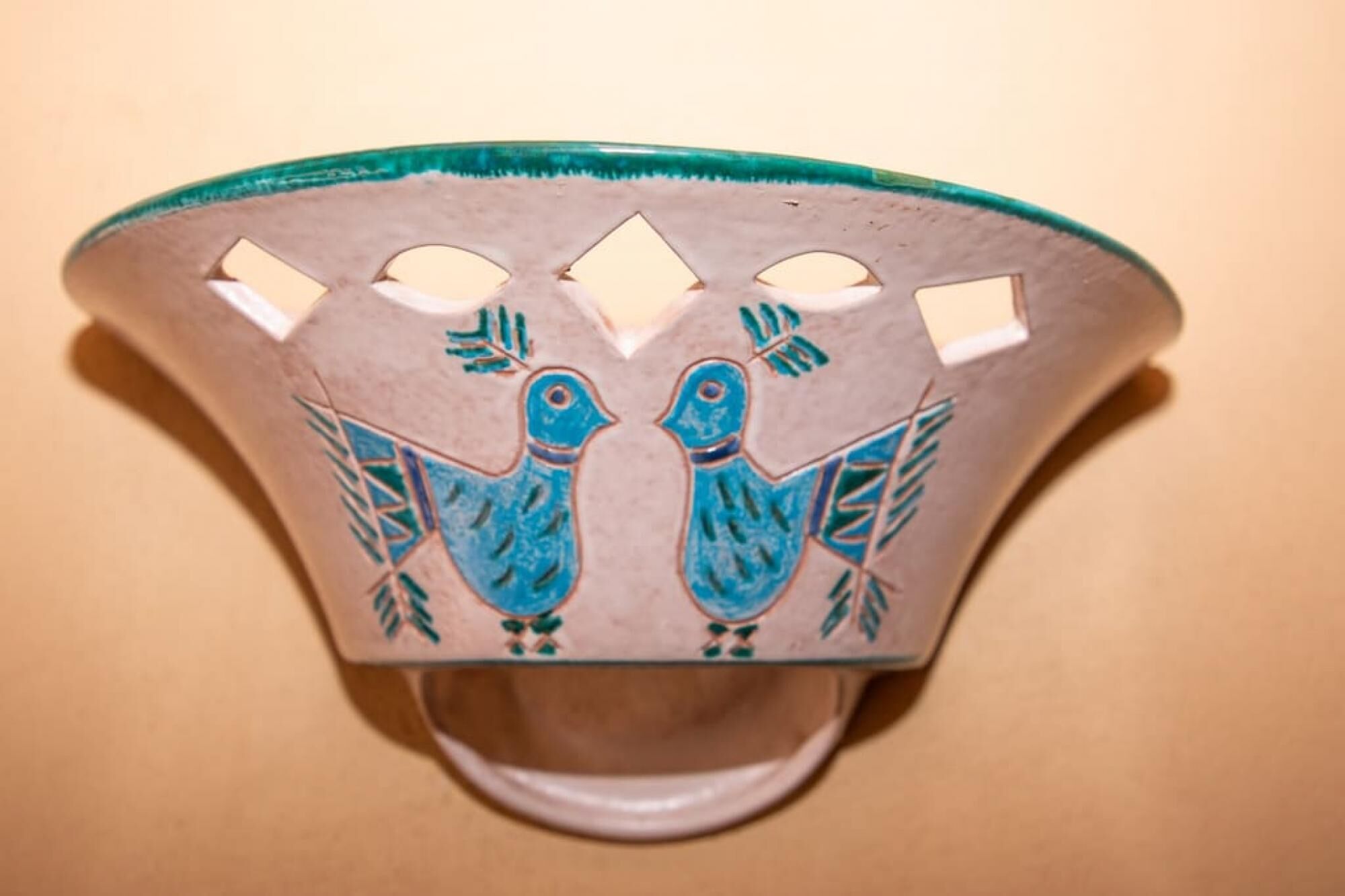 A wall-mounted decorative item with two stylized birds and cut-out shapes.