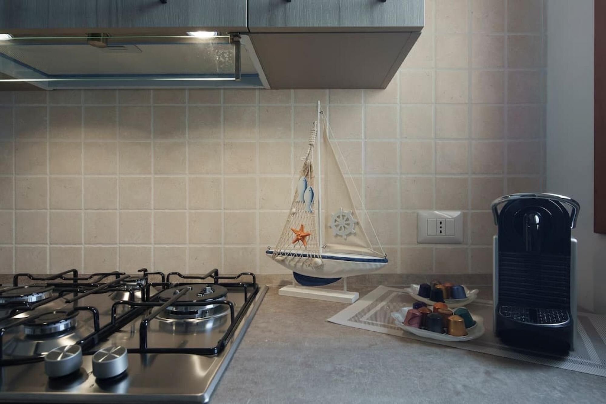 A kitchen with a gas stove, a hanging kitchen towel, and a coffee maker.
