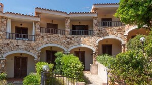 A multi-story building with stone walls and multiple balconies. - Welcomely - Casa Della Luna (Budoni)