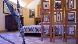 A room with a bed, a wooden photo display, and a decorative metal sculpture. - Welcomely - Casa Tipica Vista Mozzafiato (Posada)