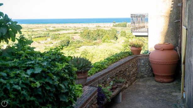 A balcony with terracotta pots and a view of a coastal landscape. - Welcomely - Casa Tipica Vista Mozzafiato (Posada)