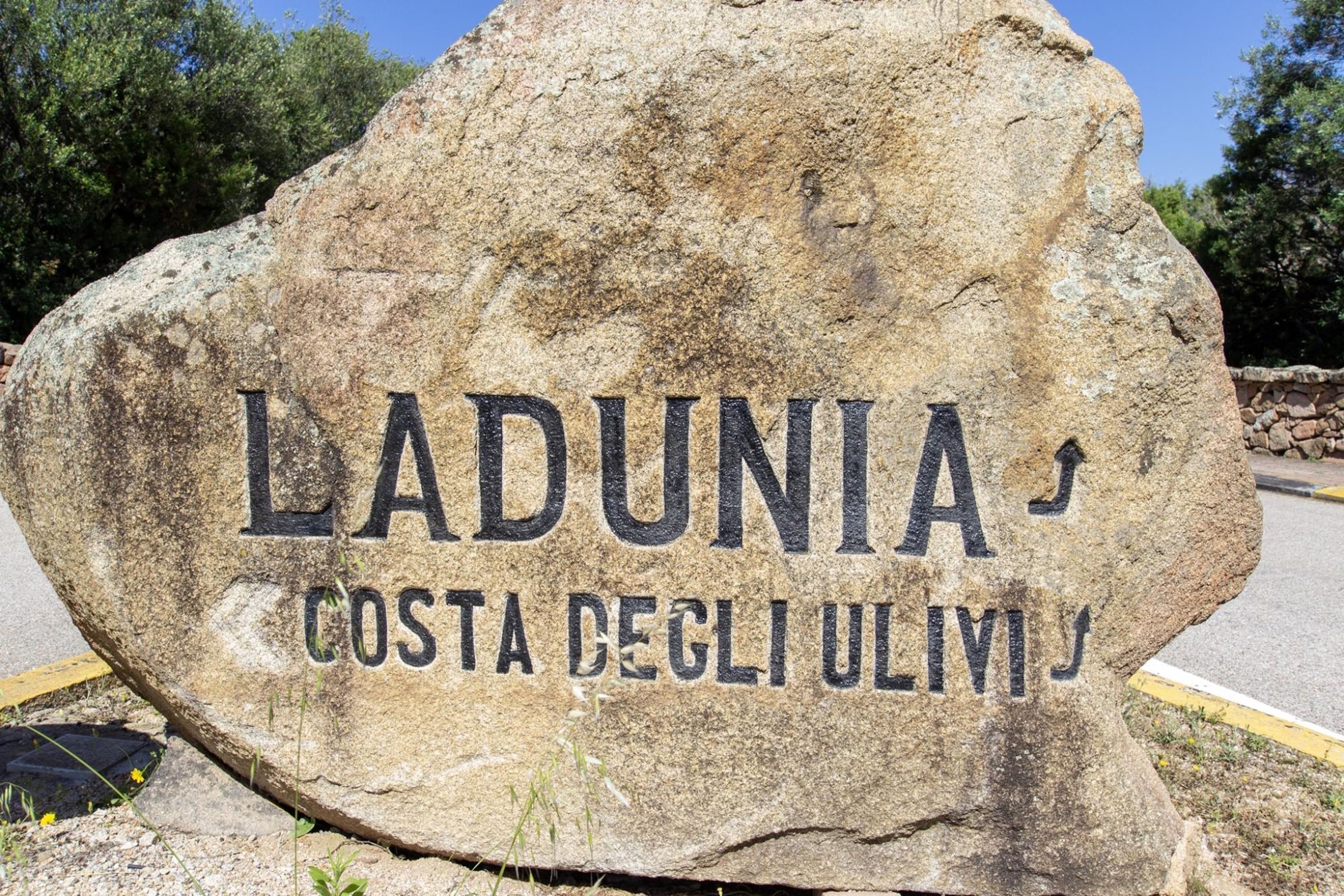 Un letrero de piedra grande con el texto "LADUNIA COSTA DEGLI ULVI" que indica un lugar.