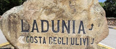 Un letrero de piedra grande con el texto "LADUNIA COSTA DEGLI ULVI" que indica un lugar.
