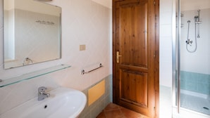 Un baño con lavamanos, espejo y ducha.