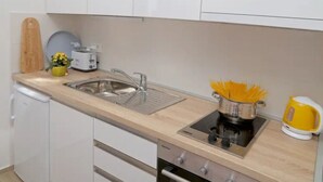 A compact kitchen with a sink, a stove, and a small countertop area. - Apartment Miriam - Studio Apartment With Sea View (Dubrovnik)