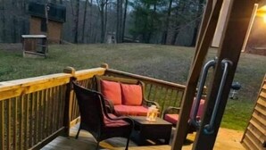 Un jacuzzi en una terraza de madera con vista a un patio trasero.