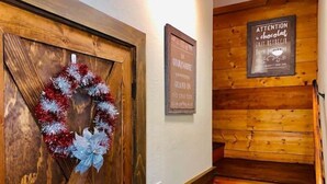 Una escalera de madera con una puerta de madera decorada con un adorno navideño.