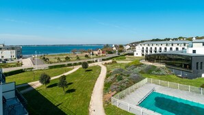 A modern hotel with a swimming pool, a view of the sea, and a well-maintained garden. - Les Thermes 532 - Vue mer avec piscine partagée (Concarneau)