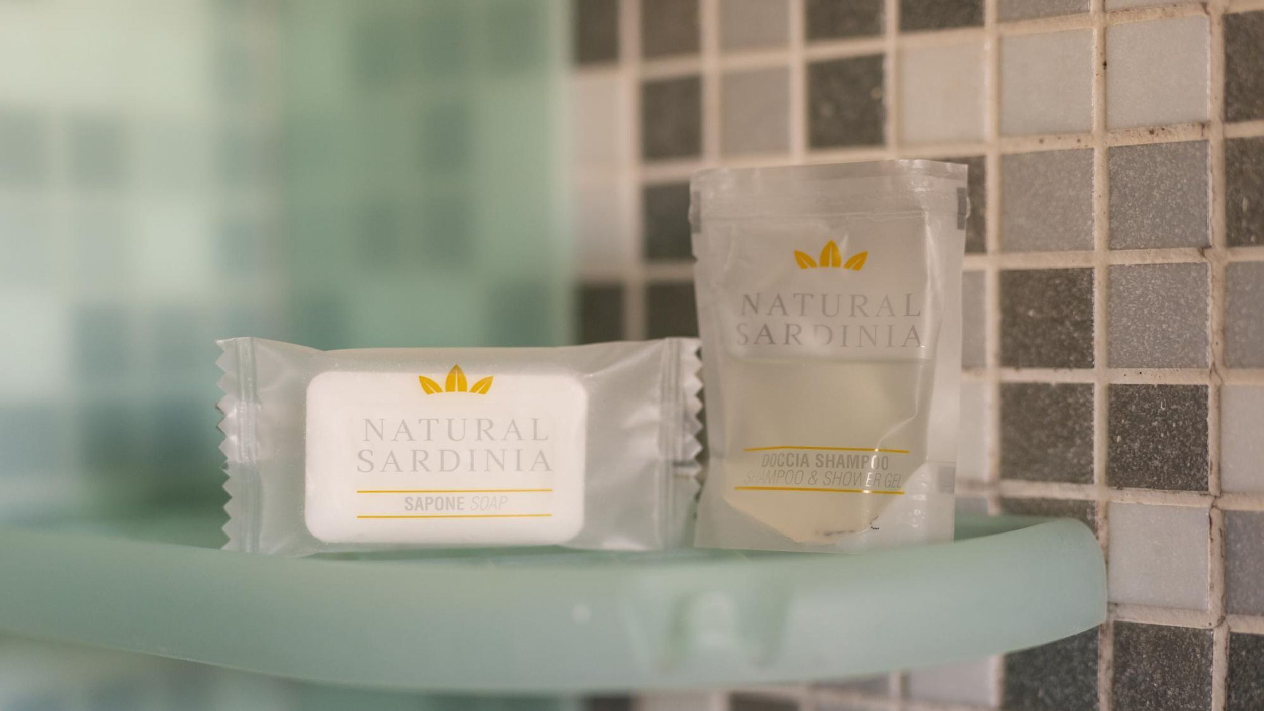 Two Natural Sardinia soap bars on a bathroom shelf.