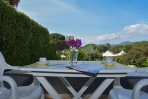 A table set outdoors with a view of a mountainous landscape.