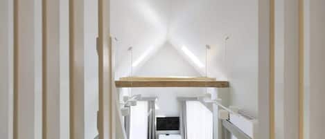 Ein modernes, minimalistisches Interieur mit hoher Decke und geneigtem Dach.