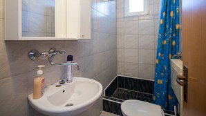 Un bagno con lavandino, specchio e servizi igienici.