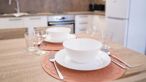 Una cucina moderna con mobili bianchi, un forno a microonde e un lavello.