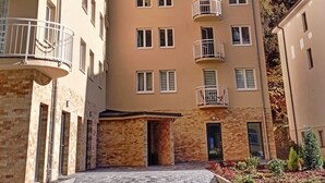 Un edificio residenziale a più piani con balconi, facciata in mattoni e cortile lastricato.